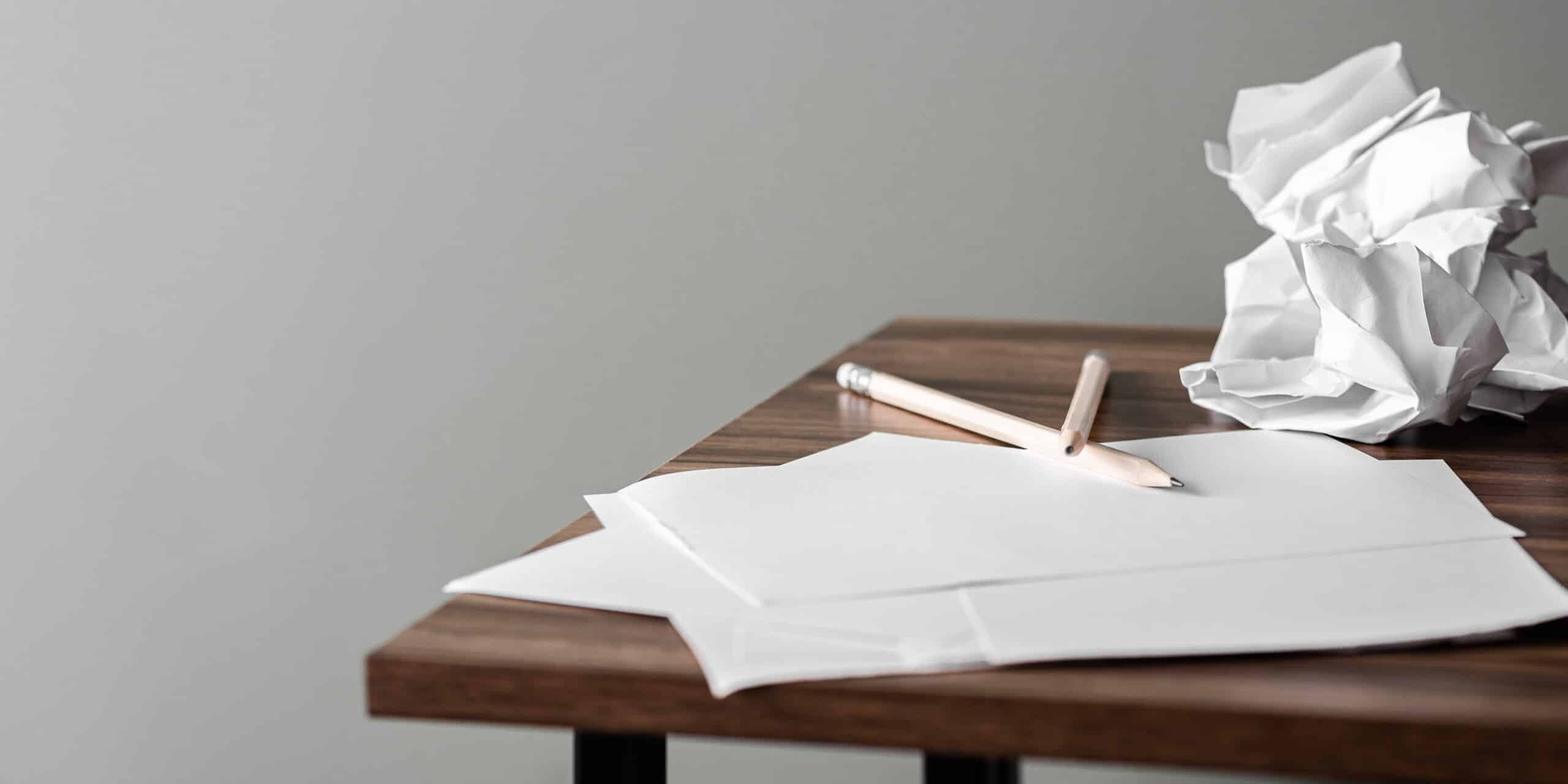 view of paper, pencils, and desk workspace, symbolizing a business owner reviewing their underperforming website.